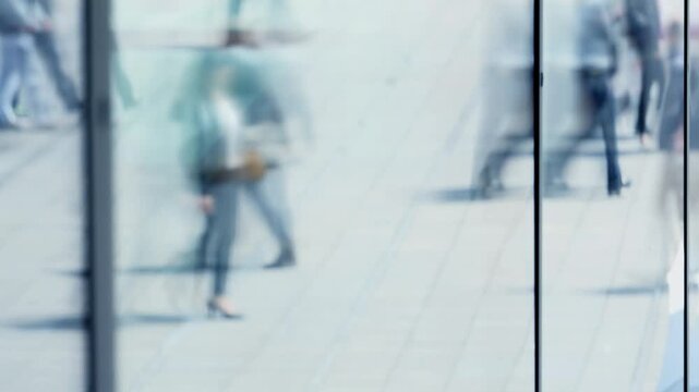 silhouettes of people walking un crowded urban city street in business district