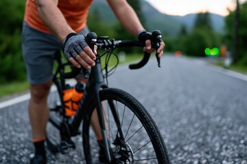 Fototapeta premium Adult cyclist adjusting handlebars on rural road before training ride