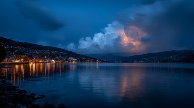 Serene twilight over calm lake with glowing reflections from city lights under a dramatic stormy sky filled with clouds and hints of lightning in the distance