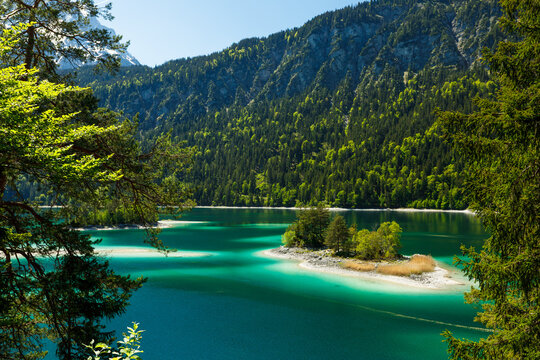 Travel landscape of Eibsee lake in Zugspitze Alps and island in mountains in Bavaria, Germany, scenic summer nature panorama with forest