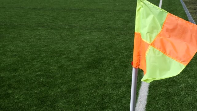 Orange soccer corner flag on green field