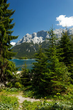 Travel landscape of Eibsee lake in Alps in Bavaria, Germany, scenic summer nature panorama with forest, mountains peak