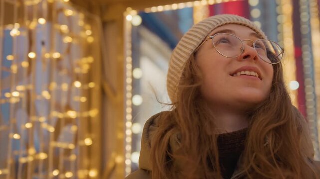 Caucasian woman gazing at glittering lights, upward smile, parka and knit beanie, round glasses catching golden bokeh, evening urban backdrop, hopeful festive mood, intimate closeups