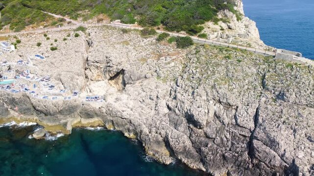 Stunning aerial perspective of Capri Faro beach with bathers enjoying clear Mediterranean waters