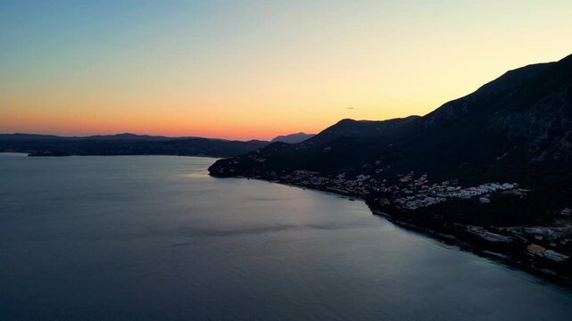 Scenic drone footage of the sunset over the mountains of Corfu, Greece. Shot on a 4k at 60 fps on a DJI Mini 3 Pro in Raw Footage (uncolorgraded), D-Log film