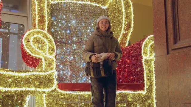 Young woman enjoying. Bright young explorer relaxes amid city holiday illumination celebrations. Fairhaired young woman eagerly observes vibrant and colorful holiday lighting display in city
