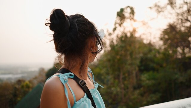 Woman admiring sunset view over landscape from temple viewpoint in chiang mai