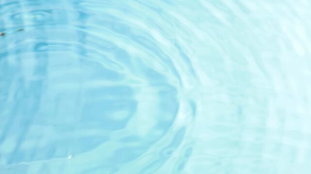 raindrops fall on a flat, clean surface of water and form circles on the water
