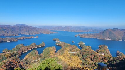 Obraz premium High angle view of scenic lake with unique islands under a clear blue sky in fall