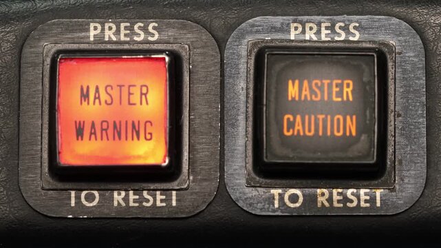 Close up of electrcial switch buttons. Master Warning Master Caution annunciator lights indicate issues and faults with an aircraft in flight. Press to reset buttons extinguish the alerts. 