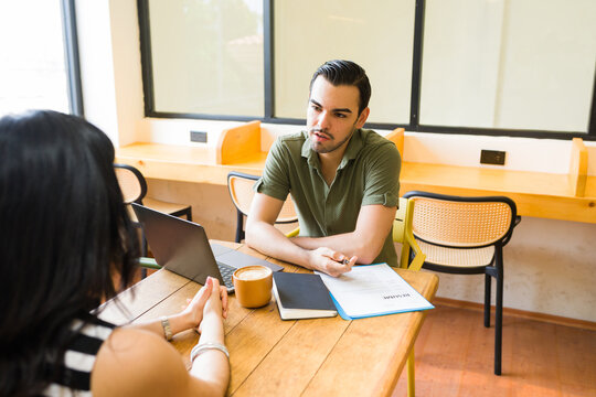 Male candidate discussing career opportunities during a modern job interview in a casual cafe coffee shop setting