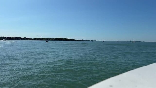 VENICE, ITALY - MAY 17, 2026: Time-lapse of Bernini boat and other vessels moving in the Venetian Lagoon on a sunny day.