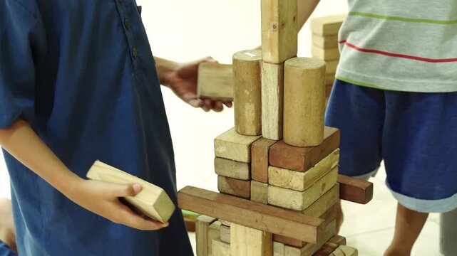 Children playing wooden block tower game in motion video clip