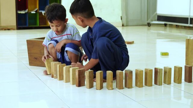 Children playing with wooden blocks in a classroom video footage