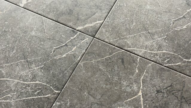 Charcoal grey marble tile texture background with white veins and diagonal cross grout lines