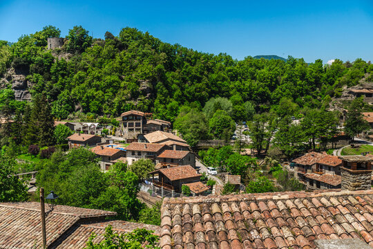 Panoramic view over rooftops of Rupit village surrounded by lush green forest in Catalonia, Spain