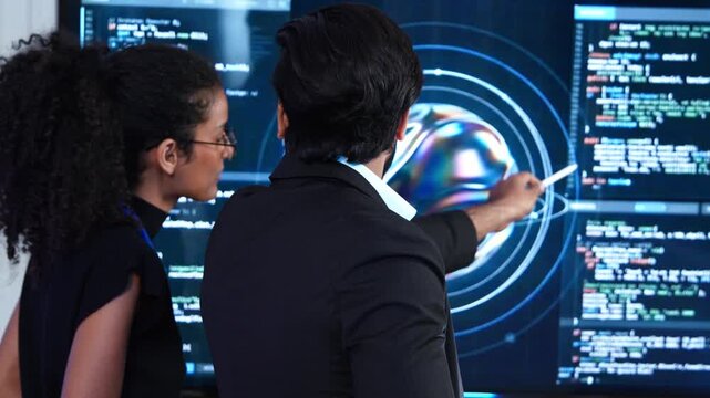 Team of professional software engineer look at monitor screen to analyze AI data visualization script. Expert developer collaborate to review machine learning program code during business meeting
