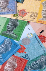 Malaysian ringgit money bills pile on table. Malaysia banknotes of MYR currency close up. © Larysa