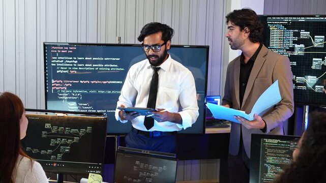 Professional software engineer explaining Python code and system workflow on screen to IT manager holding document file during corporate tech project presentation in office team meeting