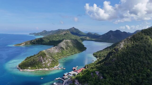 Aerial view of a tropical island bay with turquoise water and lush green mountains