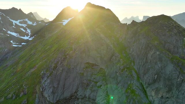 Aerial shot of the ocean meeting the mountains along the beautiful coast of Northern Norway near the town of Reine