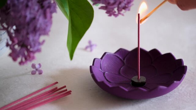 Lighting a Japanese Incense Stick in Holder with Lilac Flowers, Zen Relaxation Scene