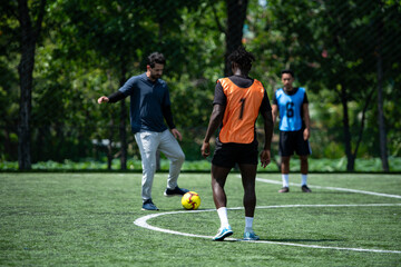 Obraz premium Soccer coach leading a practical training drill with players on an outdoor football field