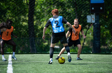 Fototapeta premium Soccer coach leading a practical training drill with players on an outdoor football field