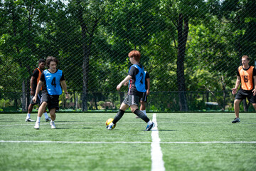 Obraz premium Soccer coach leading a practical training drill with players on an outdoor football field