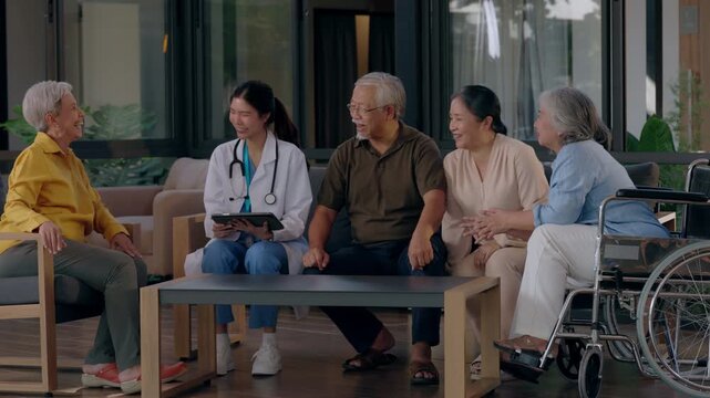 Attentive doctor provides medical consultation using digital tablet for senior group inside nursing home facility sharing health information bringing happy comforting wellness care and relaxed support