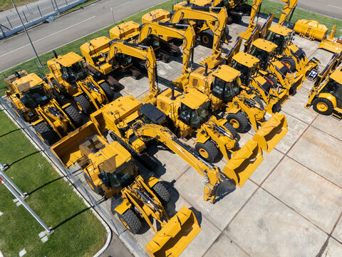 New hydraulic excavators and tractors parked at a construction machinery dealership