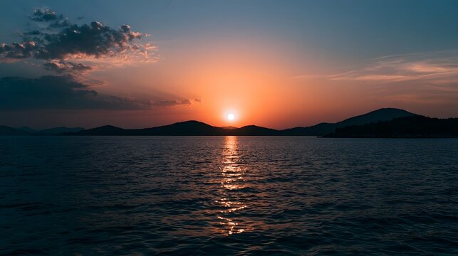 Dramatic sunset light reflects across the water and sky creating a vibrant and serene seascape