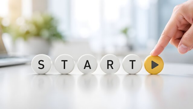 Project initiation concept hand pressing yellow play button on white circular tiles spelling start word in bright office