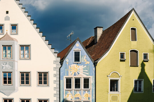 Colorful Bavarian facades rising boldly beneath dramatic gathering clouds