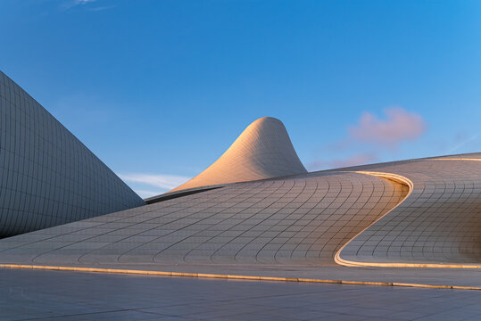 Baku, Azerbaijan - February 4, 2020: Abstract curved shapes of Heydar Aliyev Center in Baku, Azerbaijan in sunset light on clear February evening.