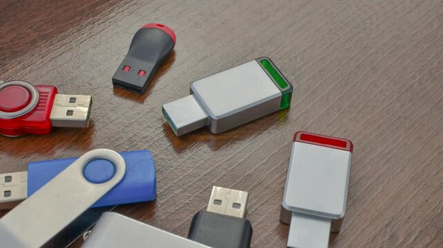 Close-up of assorted USB drives on a wooden surface, offering stylish storage options. Variety of USB drives in detail, providing storage solutions on a wooden base.