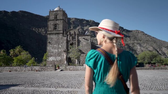 A senior woman starts her journey to San Javier Mission in Baja California Sur, Mexico, feeling excited at sunrise