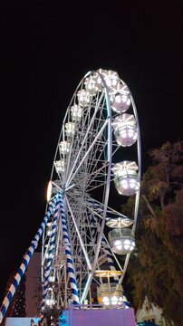Low angle view close-up of a ferris wheel spinning at night.