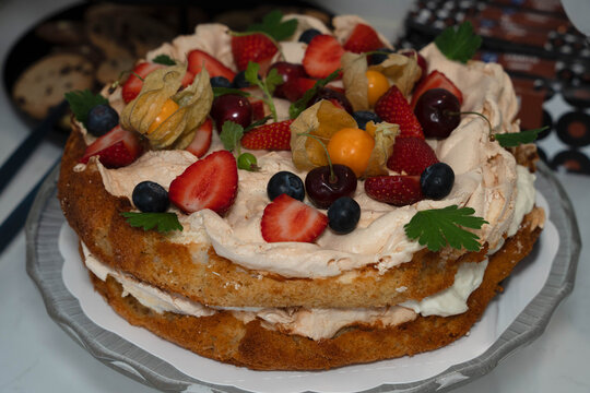A high-angle studio shot of a traditional Scandinavian Brita cake (Britakakku) served on a glass platter. 