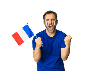 Naklejka premium French sports fan cheering passionately, celebrating victory with flag painted on cheeks