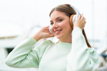Naklejka premium Young pretty blonde woman listening music