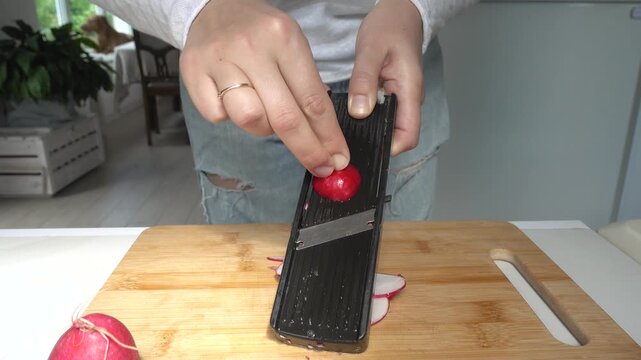 Hands slicing fresh red radishes. Symbolizes healthy food preparation. Ideal for nutrition, vegan lifestyle, and culinary content. Bright, clean kitchen scene
