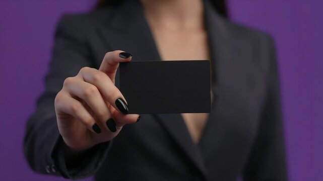 Business card held by professional woman in formal black suit jacket showcasing blank template for branding video motion clip