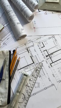 Architect workspace with blueprints, rolled plans and clipboard, construction drawings, project planning, engineering documentation and architecture office