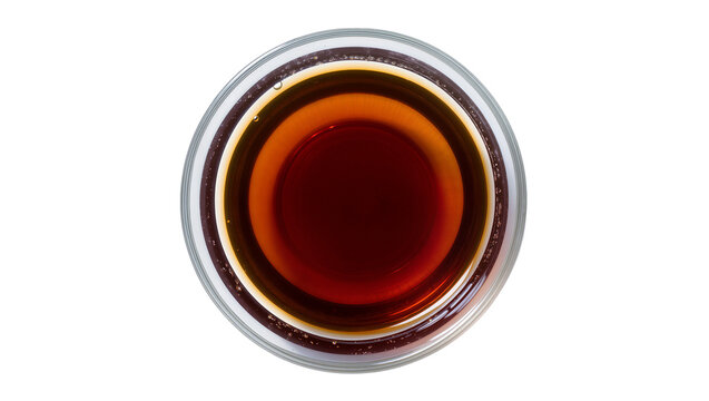 Dark amber liquid in clear glass bowl top view