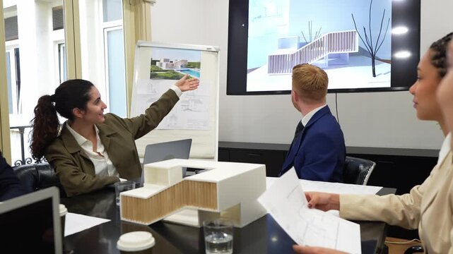 Professional architects and real estate developers discussing a new building project. A businesswoman presents an architectural model in a modern office