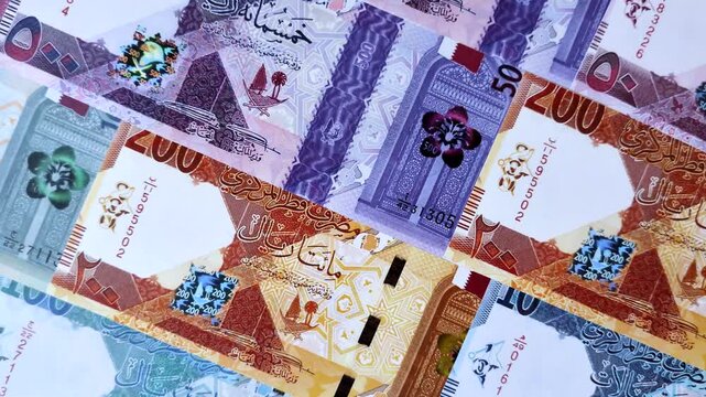 Qatar paper money, the Qatari riyal as a tool for financial transactions and trade. Qatari money as a business background for your design