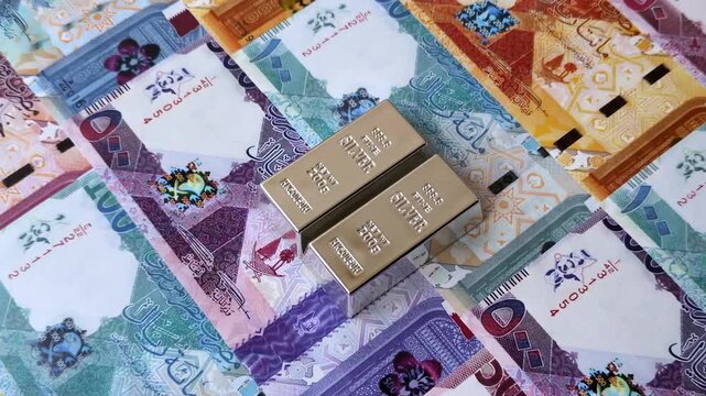 A silver bar, white metal against a backdrop of Qatari money, as a concept for the sales market. A silver bar as a background for your design