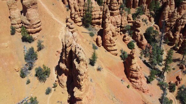 Cinematic drone footage flying over Dixie National Forest in Utah. Stunning aerial view of dramatic red rock spires, hoodoos, and geological formations similar to Bryce Canyon. 