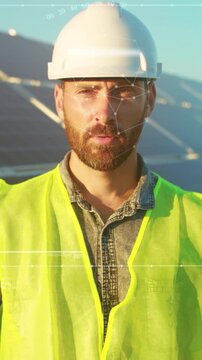 Male engineer professionally assessing solar panel setup with protective gear during golden hour sunlight